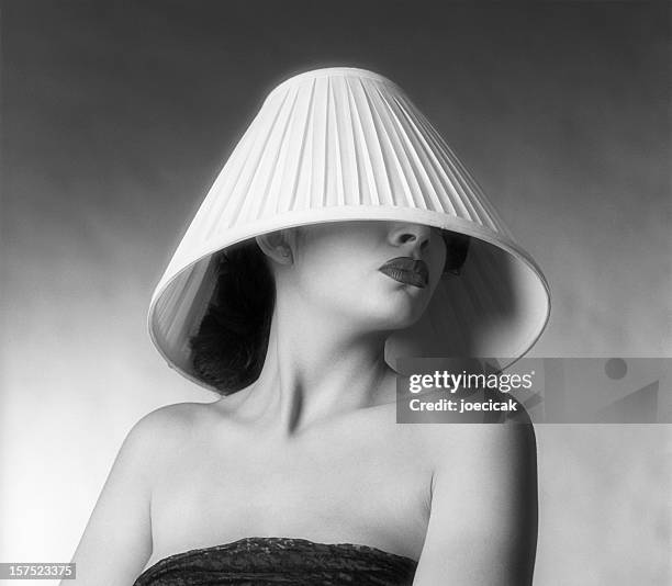 a fashion shot of a woman with a lampshade on her head - lamp shade stock pictures, royalty-free photos & images