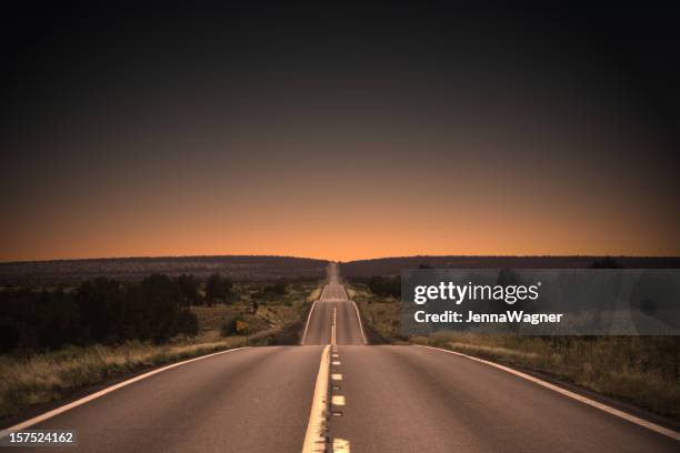 highway auf den sonnenuntergang - hill stock-fotos und bilder