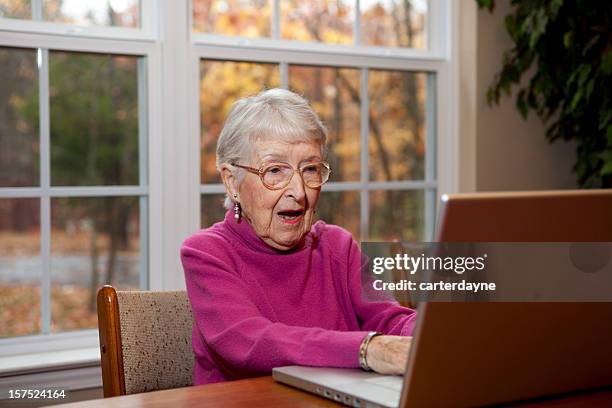 überrascht und schockiert senior frau, die ihre großmutter am computer - grandma stock-fotos und bilder