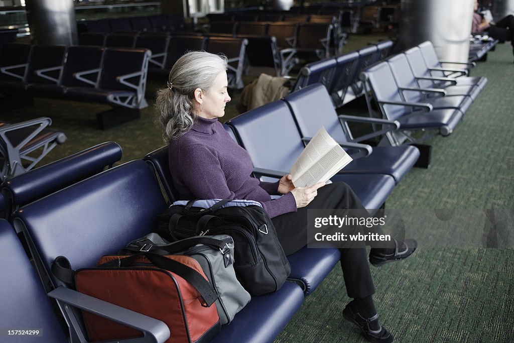 女性の読書での空港ターミナル