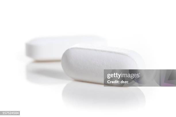 acetaminofeno blanco, oblongo de alivio del dolor pastillas en primer plano con copyspace - white oblong pill fotografías e imágenes de stock