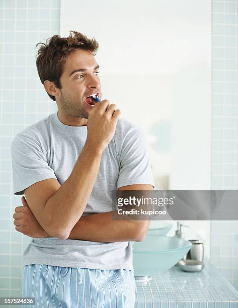 jovem rapaz escovar os dentes na casa de banho - escova de dentes imagens e fotografias de stock