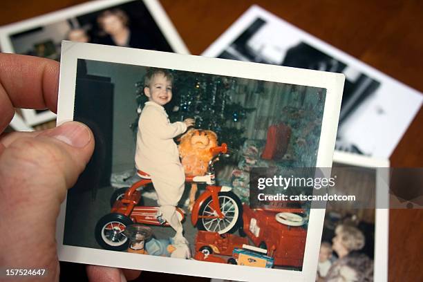 hand, die hält vintage foto des jungen auf dem dreirad an weihnachten - christmas photos stock-fotos und bilder