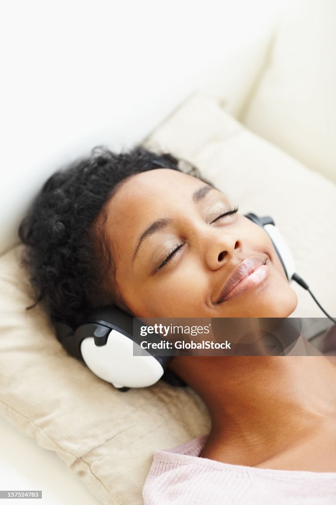 Smiling African American young lady listening to music