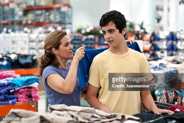 mutter und sohn shopping für kleidung - teenager boy shopping stock-fotos und bilder