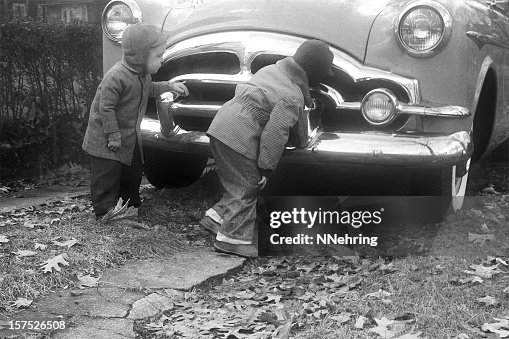 Boys inspecting Packard Coupe car 1955, retro Boys inspecting Packard Coupe car 1955, retro