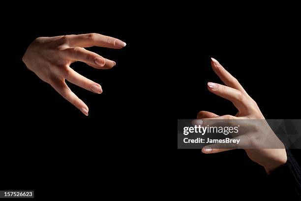 magic fingers; two intense hands hold nothing inbetween, black background - keel stockfoto's en -beelden