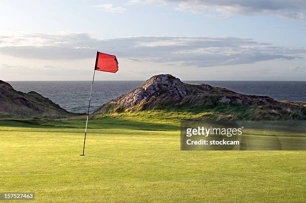 drapeau rouge sur le parcours de golf du pays de galles - drapeau de golf photos et images de collection