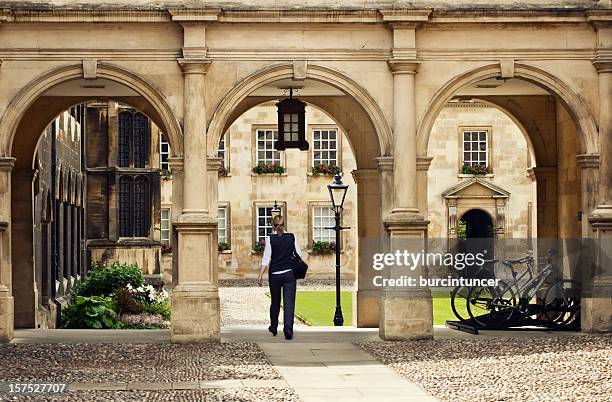 student passing through a college campus in cambridge universitiy, uk - universiteit van cambridge stockfoto's en -beelden