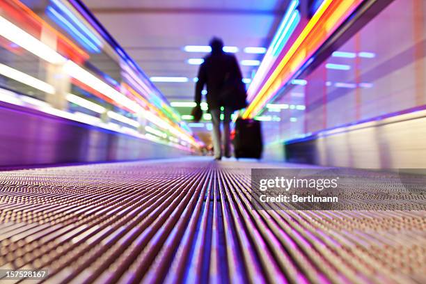 person traveling on flat escalator - airport business lounge stock pictures, royalty-free photos & images