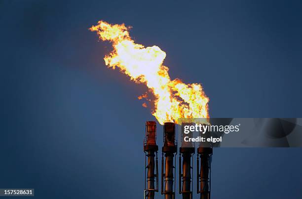 oil refinery flare stack at night with flames and pollution - flare stack stock pictures, royalty-free photos & images