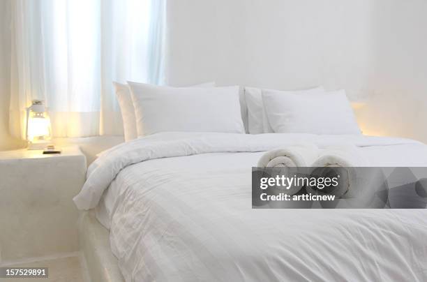 white and luxurious hotel bedroom - kussen beddengoed stockfoto's en -beelden