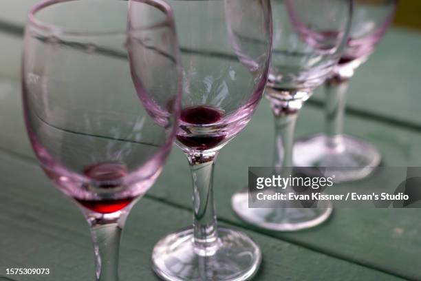 four wineglasses on a green table - evan kissner stock pictures, royalty-free photos & images
