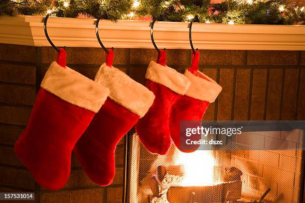 calze di natale appeso su mantel di festività caminetto - calza della befana foto e immagini stock