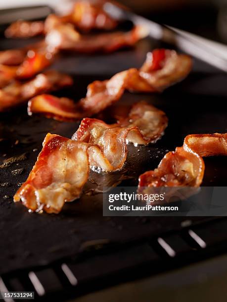 bacon frying on the grill - griddle stock pictures, royalty-free photos & images