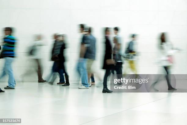 menschen zu fuß in gang, bewegungsunschärfe - young white people walking stock-fotos und bilder