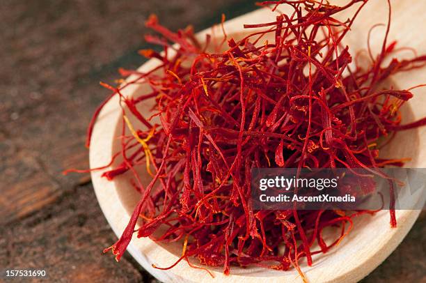a wooden spoonful of bright red saffron - saffron stock pictures, royalty-free photos & images
