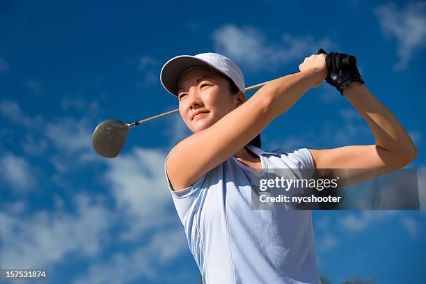 young female golfer teeing off - women golf stock pictures, royalty-free photos & images