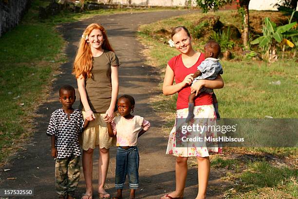 teenage girls with african children - missionary stock pictures, royalty-free photos & images