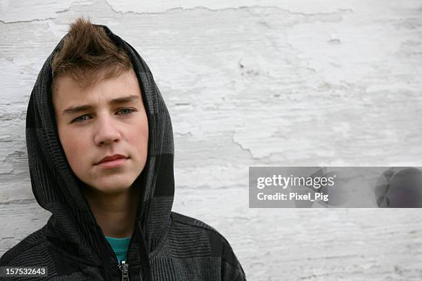 boy with black hoodie in front of white wall - angry boy stockfoto's en -beelden