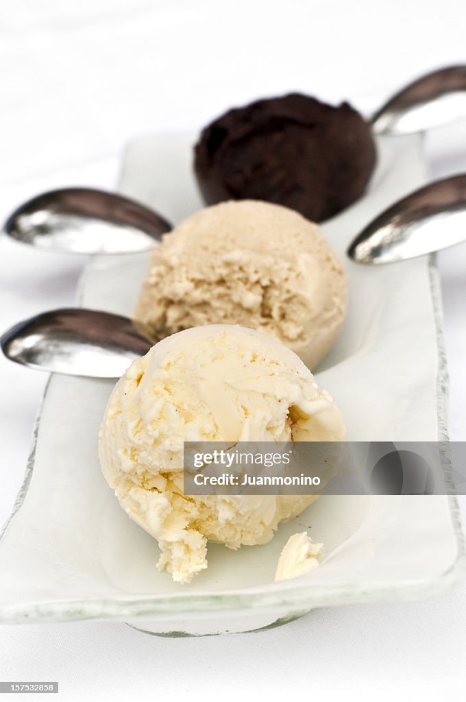 Three scoops of ice cream, two vanilla and one chocolate. 