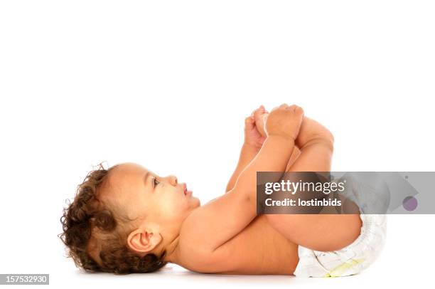 biracial baby lying on his back holding feet isolated - diaper boy 個照片及圖片檔