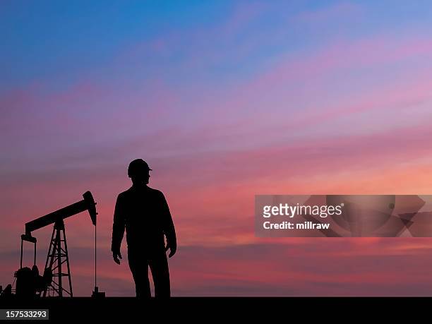 pumpjack silhouette with oil worker and pink sky - oliewerker stockfoto's en -beelden