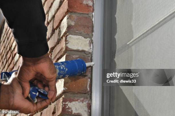 caulking gun in use - caulking stockfoto's en -beelden