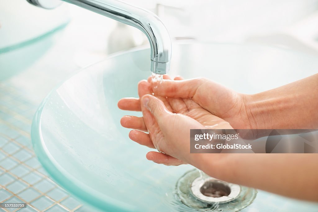 Cropped image of female washing hands