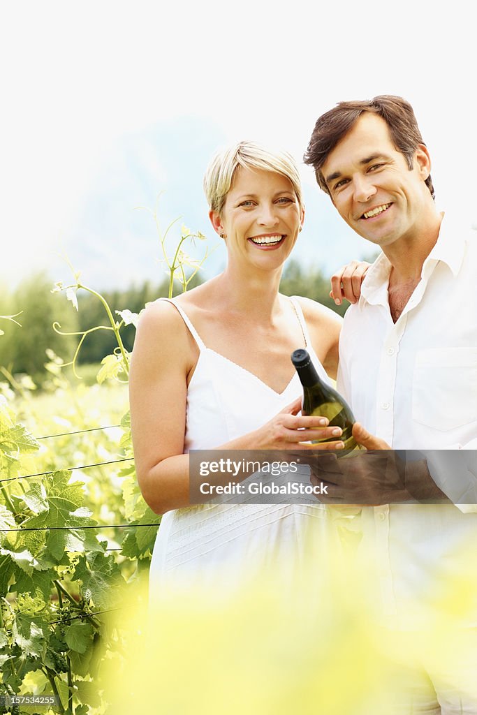 Ritratto di una coppia matura con bottiglia di vino