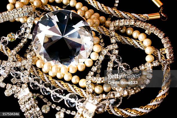 large diamond with other jewlery on black background.. - diamond necklace stock pictures, royalty-free photos & images