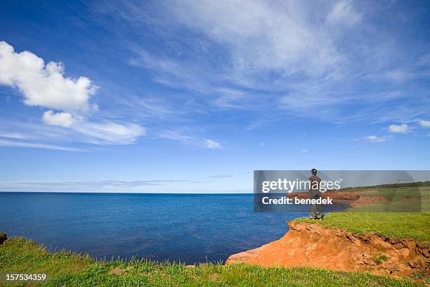 frau genießen blick auf die küste - prince edward island stock-fotos und bilder