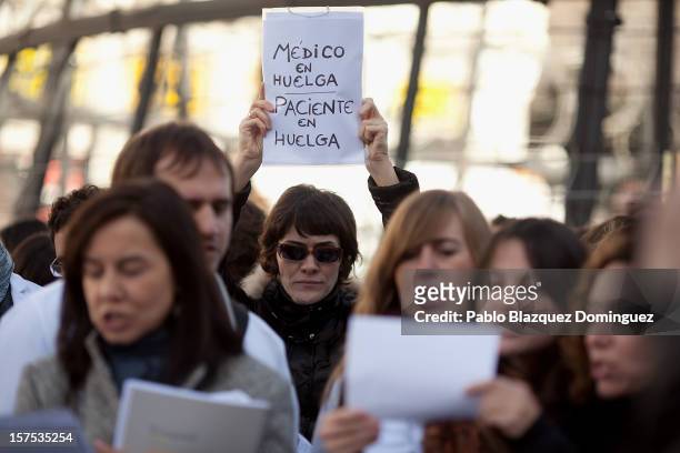 Woman holds a placard reading 'Doctor on strike. Patient on strike' amid other health workers during a demonstration at Puerta del Sol Square on...