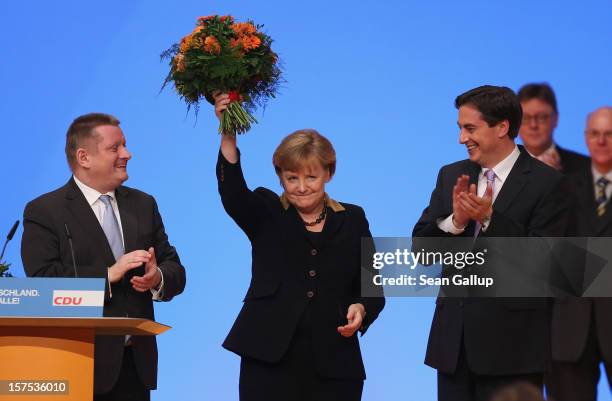 German Chancellor Angela Merkel holds up flowers after she was re-elected Chairwoman of the German Christian Democratic Union with nearly 98% of...