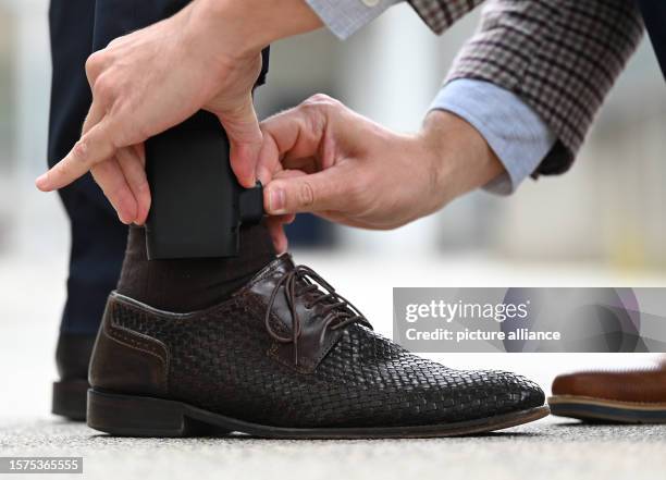 August 2023, Hesse, Weiterstadt: An electronic residence monitoring device, known as an electronic ankle monitor, is placed on a test person for...