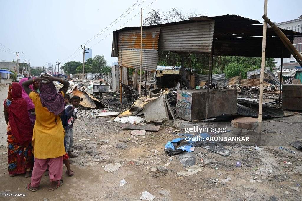 Gurgaon Riots People stand next to a burnt strucutre in Gurugram, Haryana State, on ...