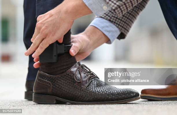 August 2023, Hesse, Weiterstadt: An electronic residence monitoring device, known as an electronic ankle monitor, is placed on a test person for...
