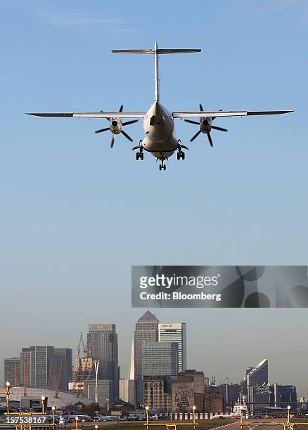 Fokker 50 aircraft, operated by CityJet Ltd., prepares to land at City Airport against a backdrop of the Canary Wharf financial district in London,...