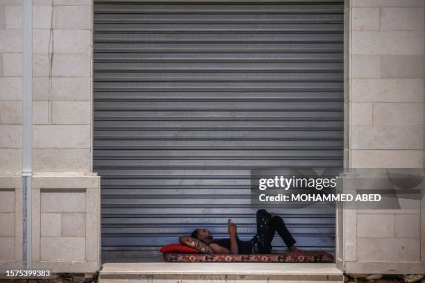 Palestinian janitor rests in the shade during his shift in Gaza on August 4, 2023.