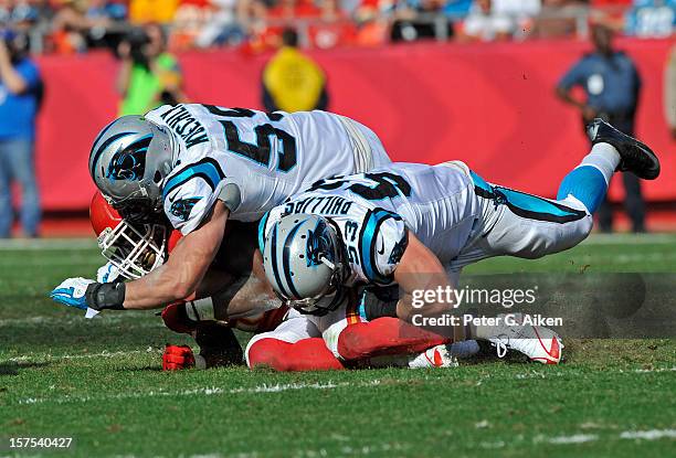 Linebackers Jason Phillips and Luke Kuechly of the Carolina Panthers tackle running back Jamaal Charles of the Kansas City Chiefs during the first...