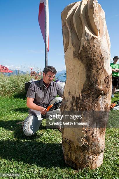 German actor Hans Sigl carves wood with a chainsaw as he visits the filming location of German-Austrian tv serie 'Der Bergdoktor' on September 17,...