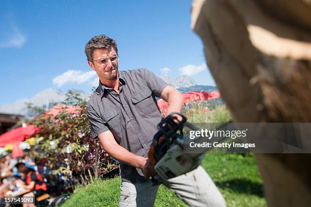 German actor Hans Sigl carves wood with a chainsaw as he visits the filming location of German-Austrian tv serie 'Der Bergdoktor' on September 17,...