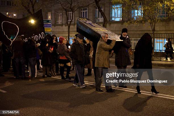 People carry a cardboard coffin during a protest mourning the public health system on December 4, 2012 in Madrid, Spain. Trade unions called for the...