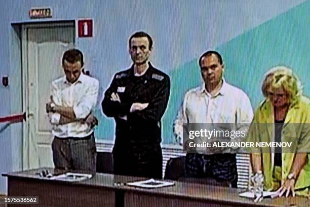 Screen shows the already imprisoned Russian opposition figure Alexei Navalny as he listens to his verdict over a series of extremism charges at the...