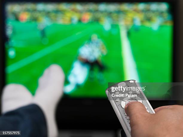 hand holding a tv remote control - american football tv stock pictures, royalty-free photos & images