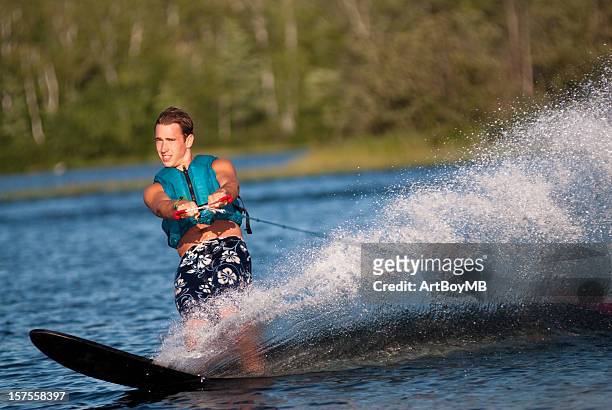 waterskiing with man shredding waves - waterskiing stock pictures, royalty-free photos & images