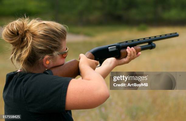 frauen eine waffe schießen - feuerwaffen abzug stock-fotos und bilder