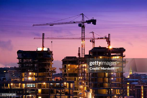 sunset at the construction site - construction cranes stockfoto's en -beelden