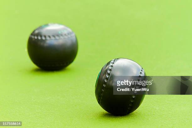 two lawn bowling balls on a green background - lawn bowls stock pictures, royalty-free photos & images