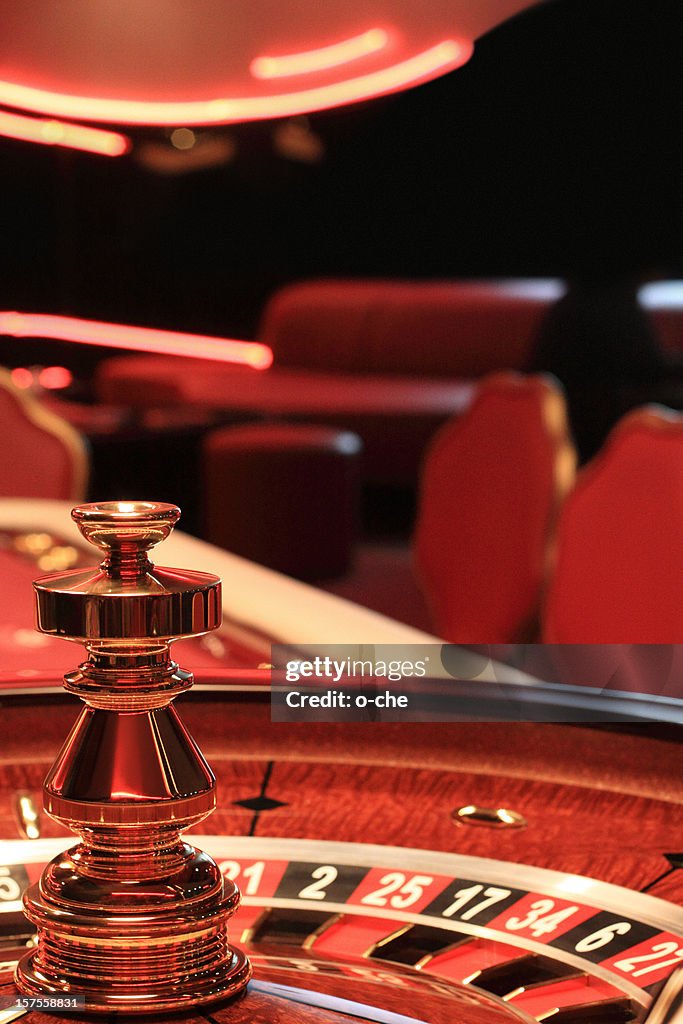 Close-up of a casino roulette table with blurred chairs